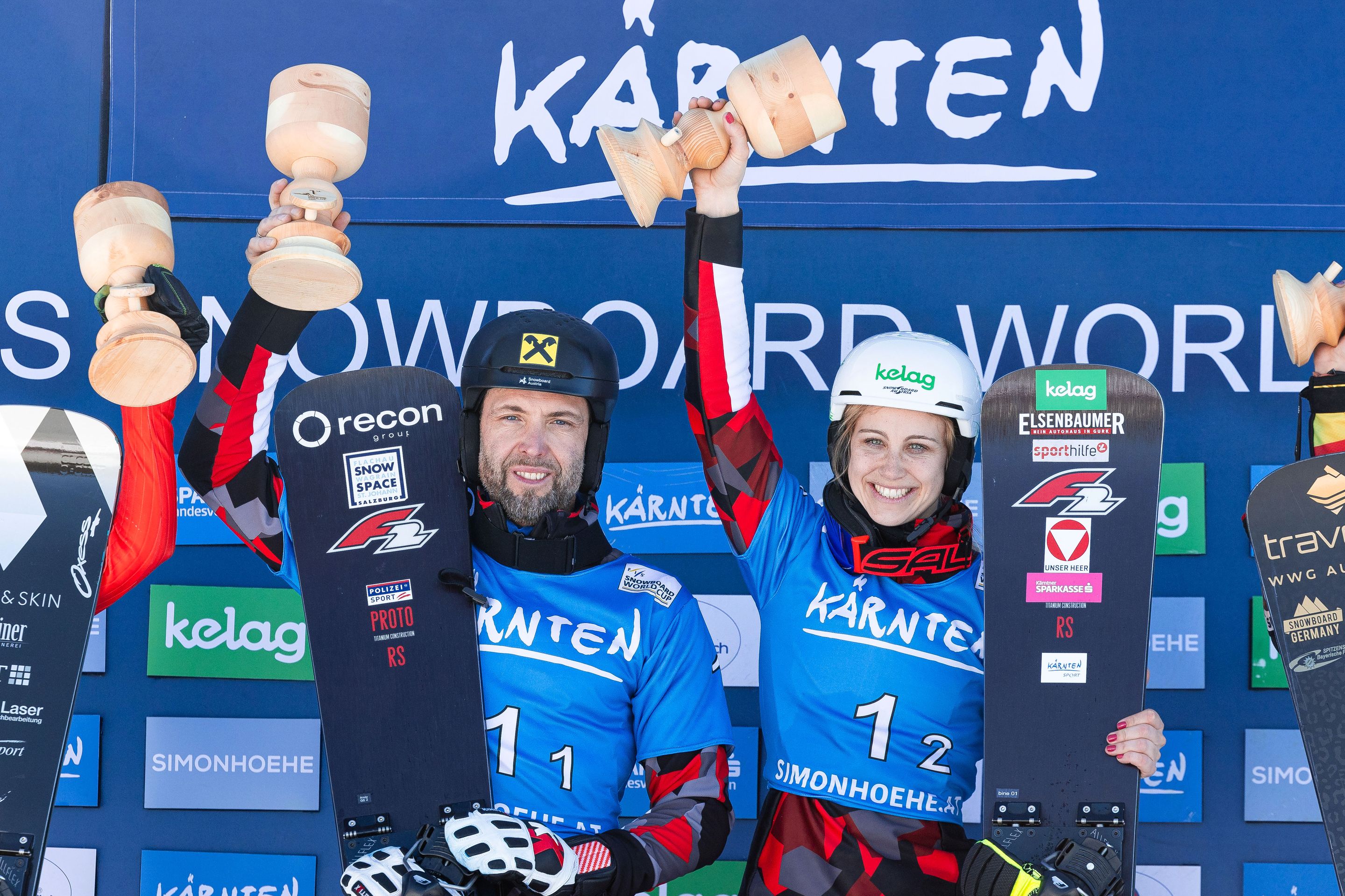 Sabine Schoeffmann (AUT) and Andreas Prommegger (AUT) lift the trophies in Austria. © Miha Matavz/FIS