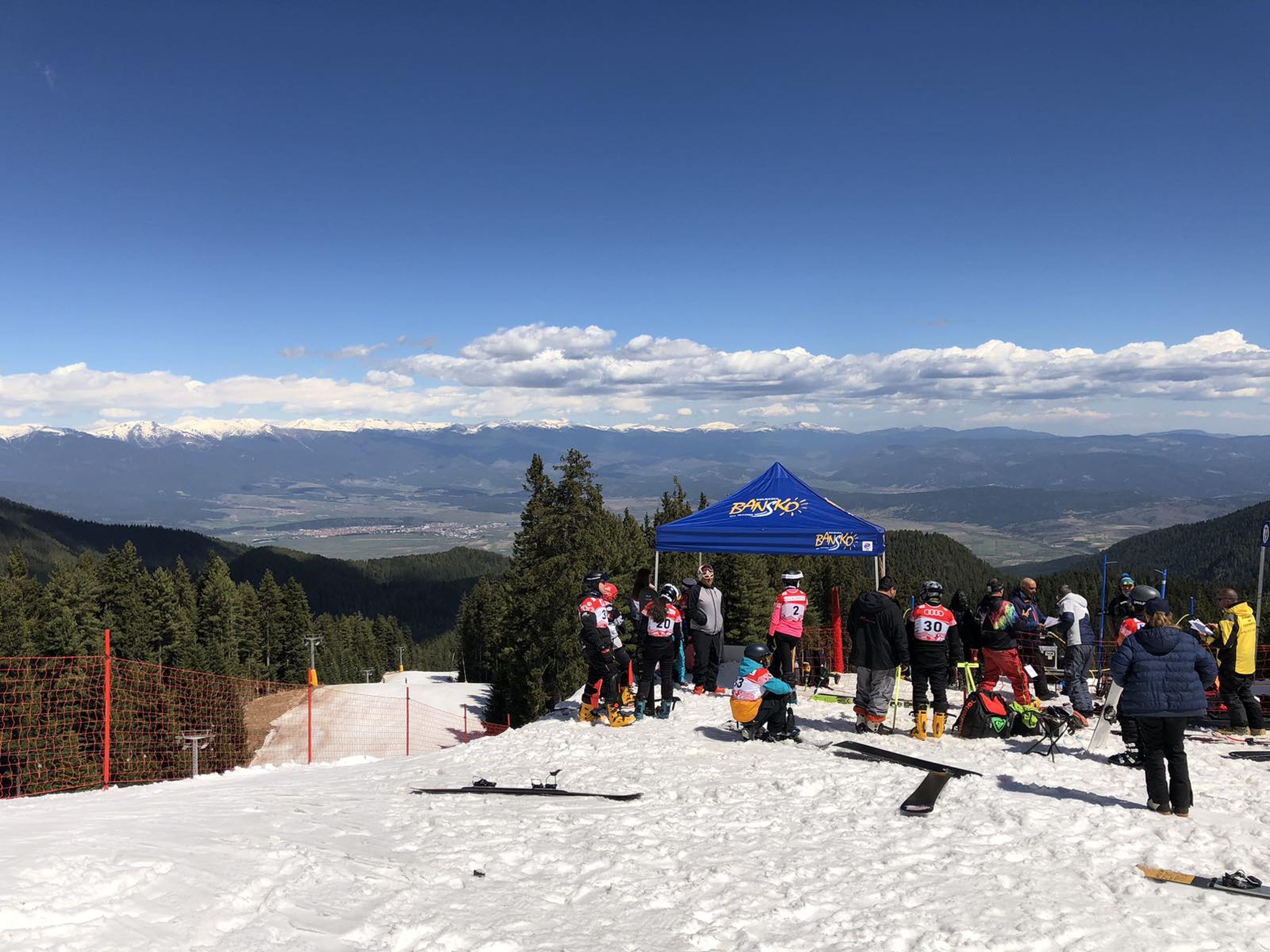 Snowboarders and coaches in the start area of the training slope in Bansko