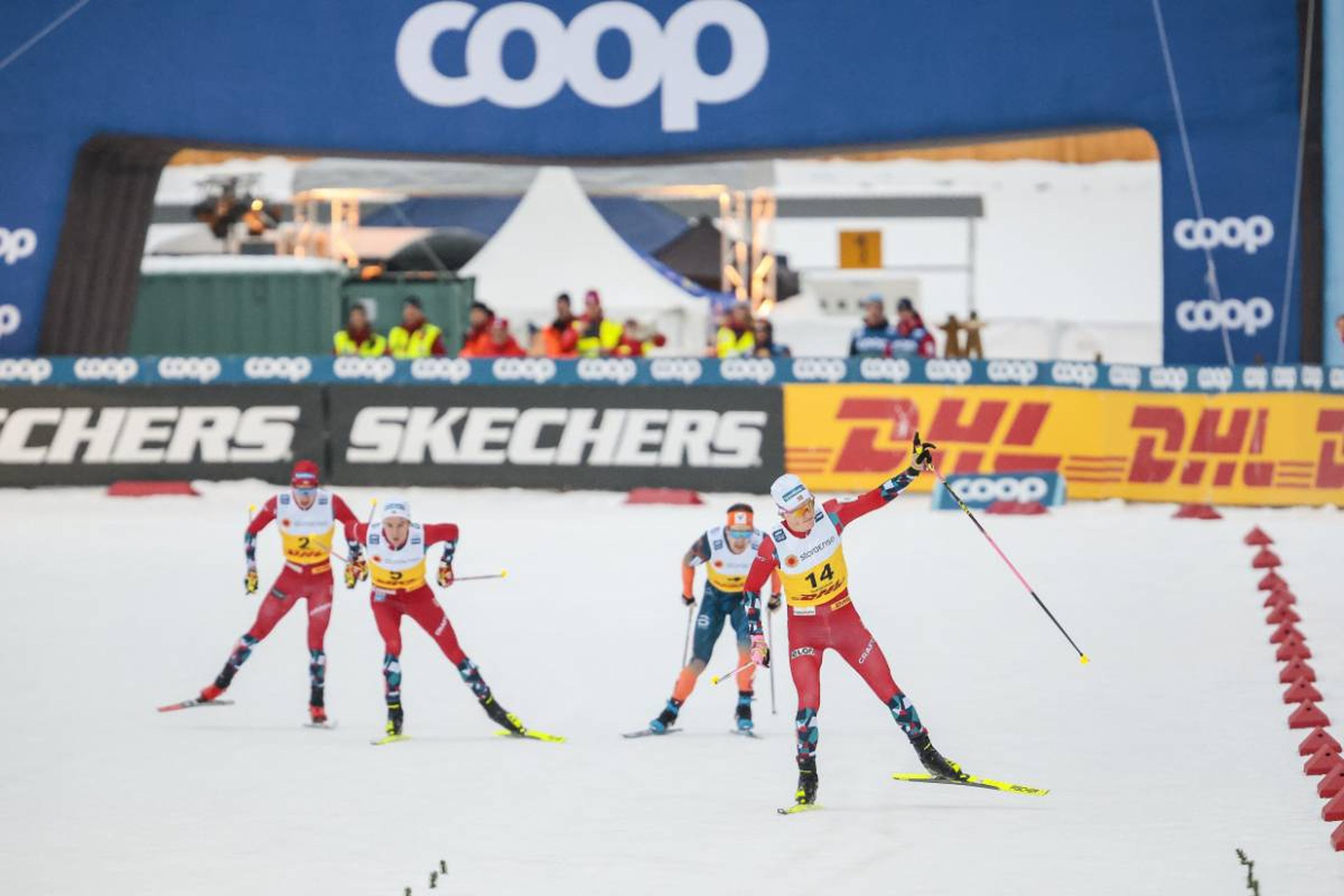 Norway's Johannes Hoesflot Klaebo took time to celebrate his victory in the men's 20km skiathlon classic free many metres before the finish line as three skiers battled for the podium positions behind him © NordicFocus