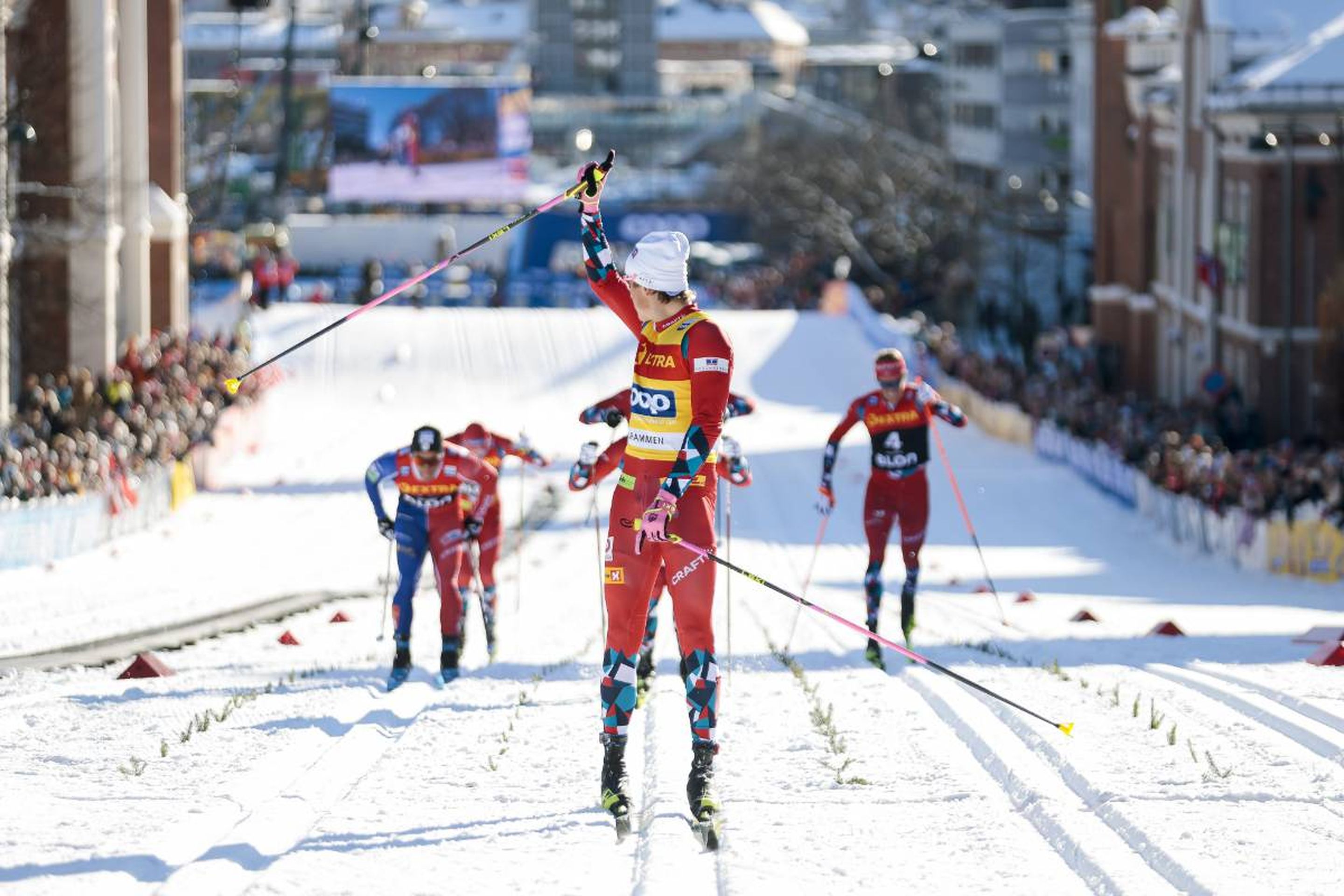 Norway's Johannes Hoesflot Klaebo cruises to the sprint classic victory, celebrating before he crosses the finish line with the battle for second place behind him: @Nordic Focus.