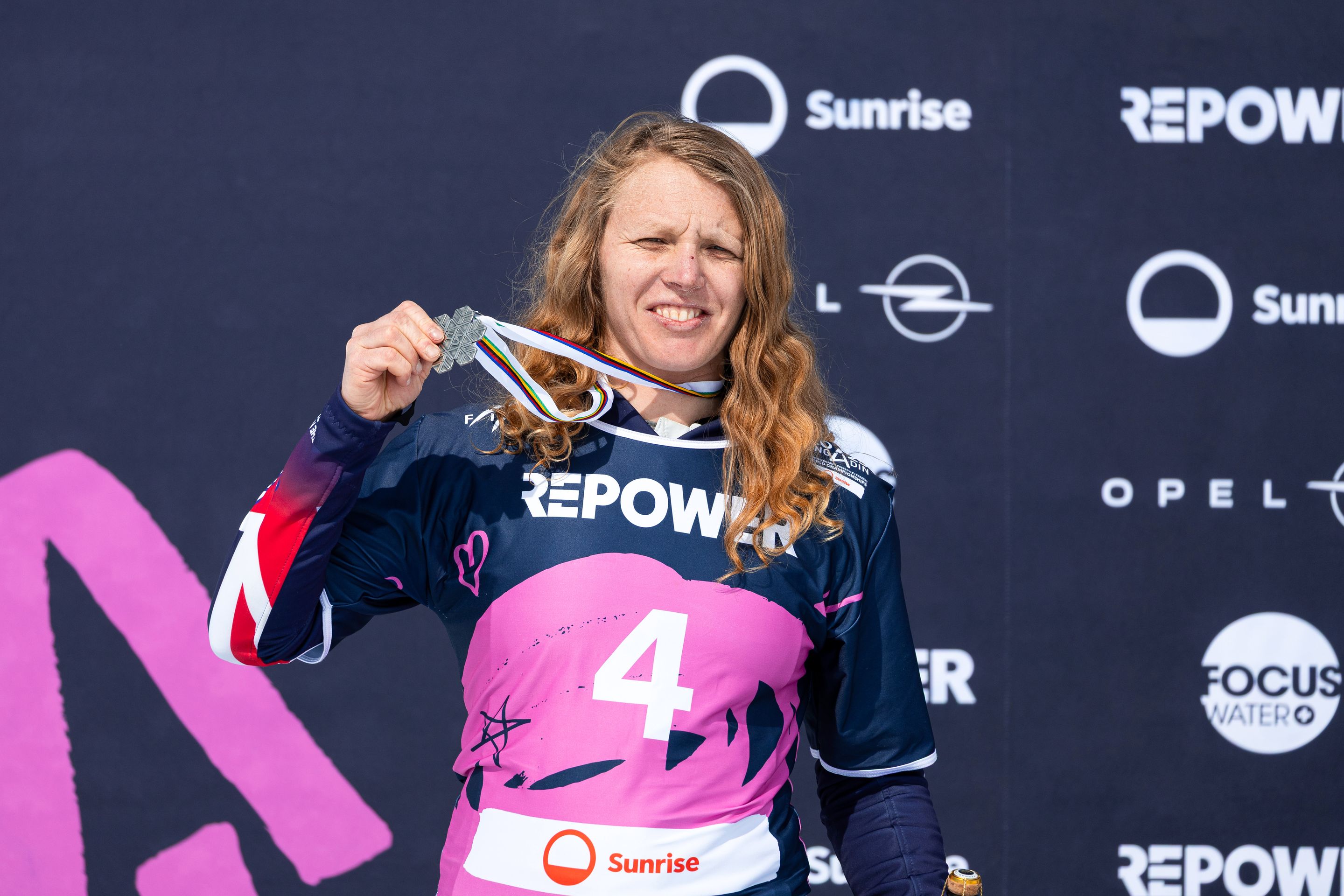 Charlotte Bankes, in a pink and navy bib, with her 2025 World Championships silver medal