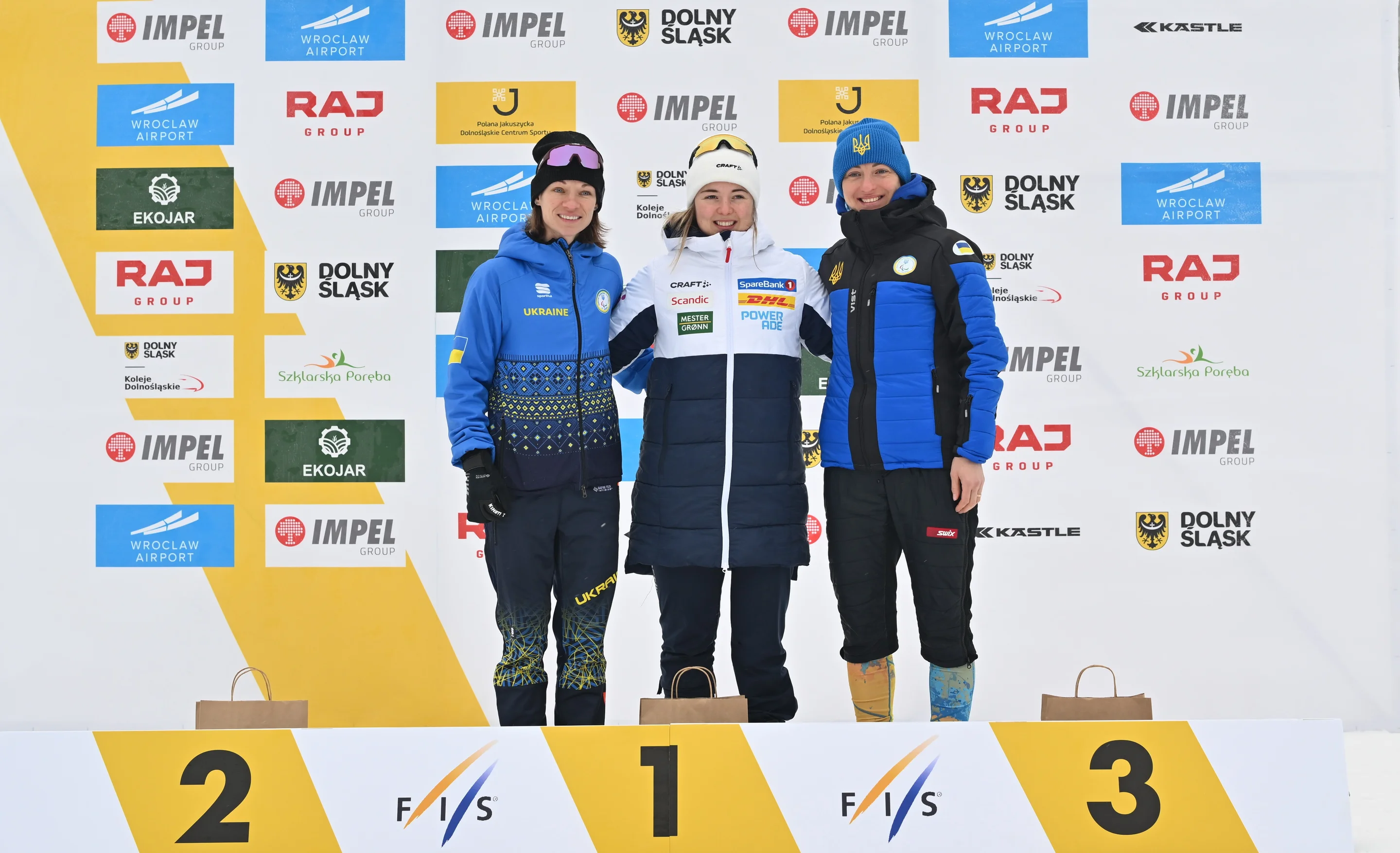 Top three athletes posing for photos on the podium