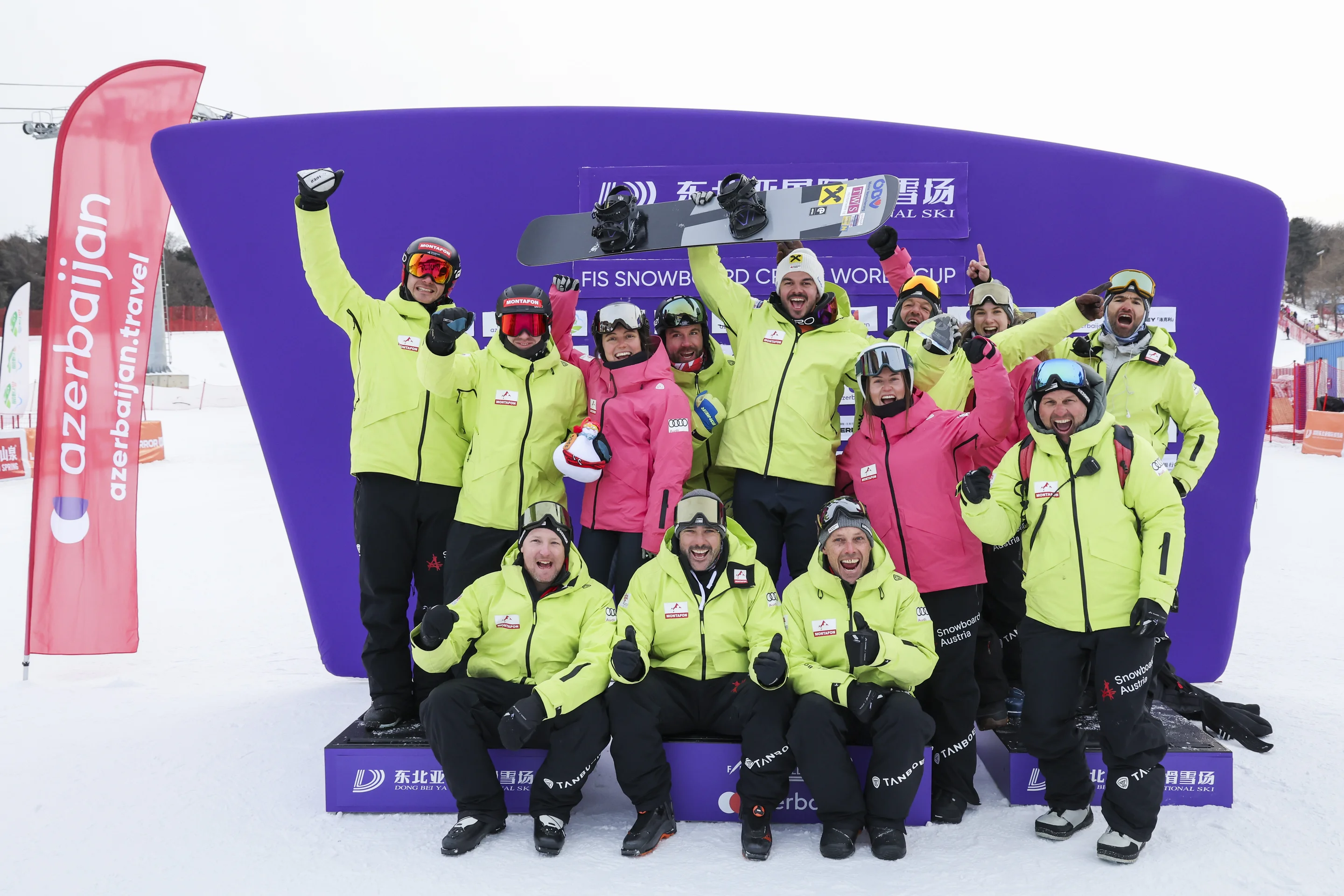 Team Austria, in lime green jackets, celebrate Jakob Dusek's World Cup victory in Dongbeiya