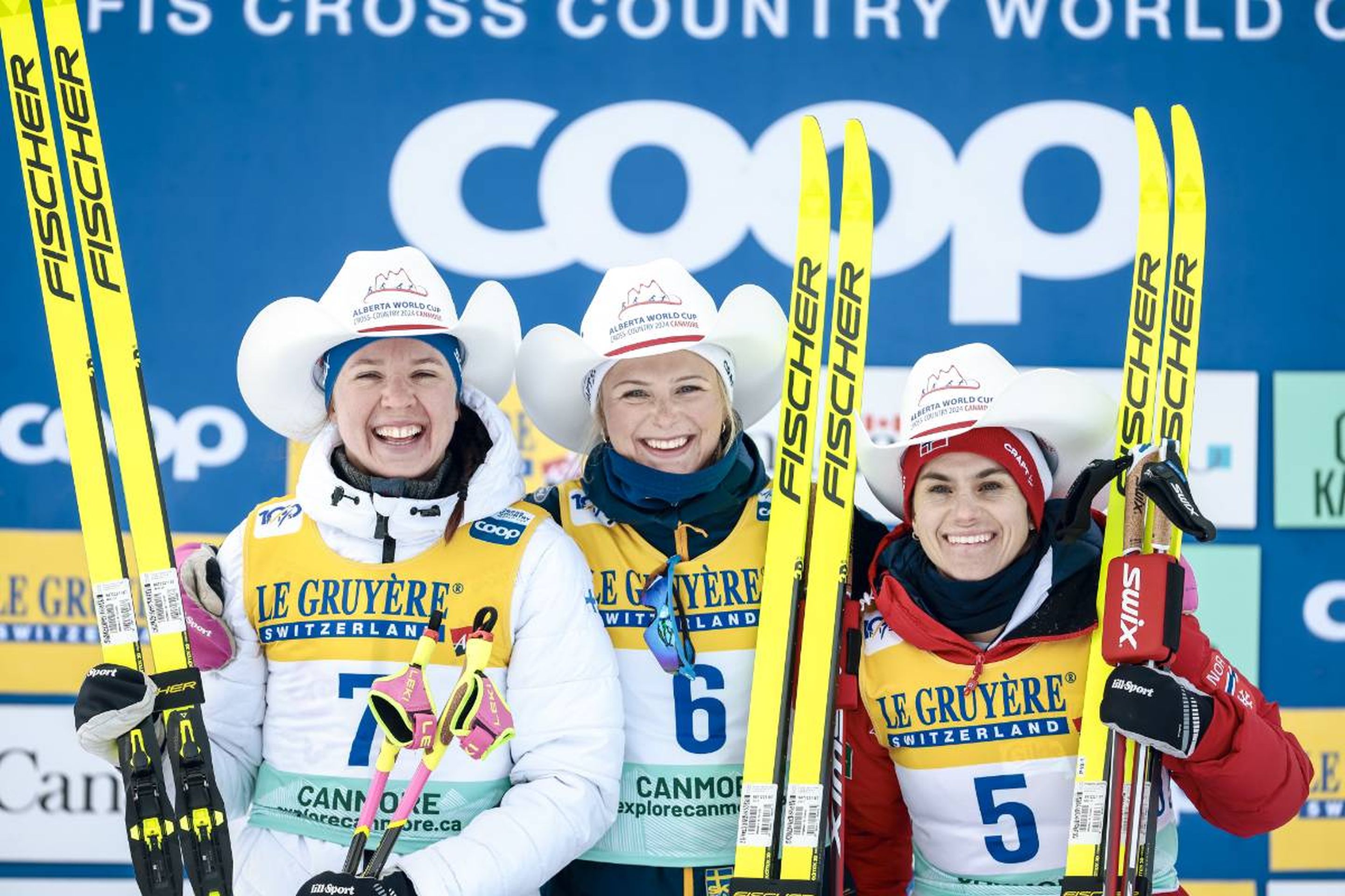 Hat's it! Kerttu Niskanen (left), Frida Karlsson (centre) and Heidi Weng (right) celebrate with their well-earned white cowboy hats on the podium © NordicFocus