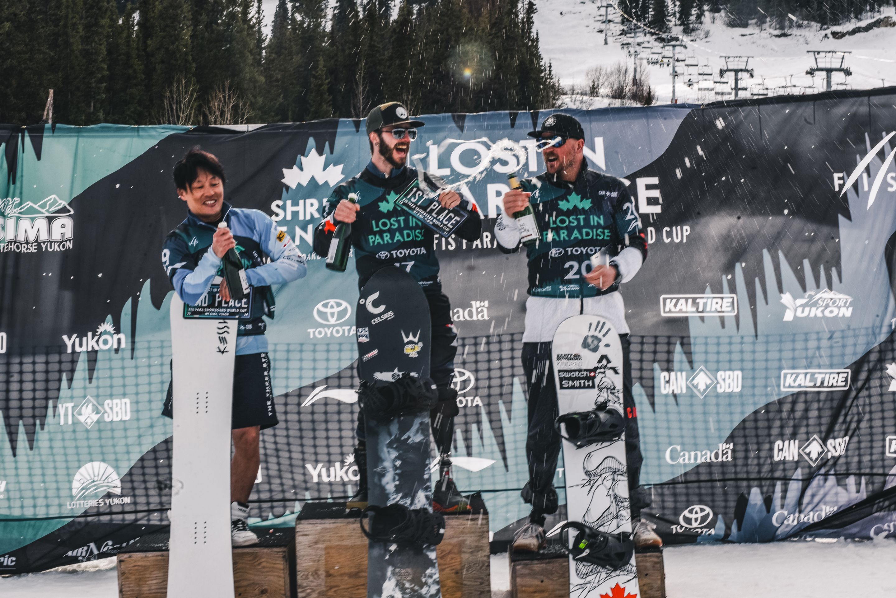 Daichi Oguri (JPN), Noah Elliott (USA) and Tyler Turner (CAN) opening up champagne bottles on the podium of the last Banked Slalom in Mt. Sima