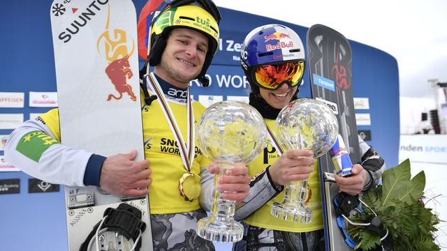 Tim Mastnak of Slovenia and Ester Ledecka of Czech Republic react after winning the small crystal globe of the Parallel Giant Slalom in the finish area at the FIS Alpine Snowboard Parallel Giant Slalom race, on Saturday, March 9, 2019, in Scuol, Switzerland.