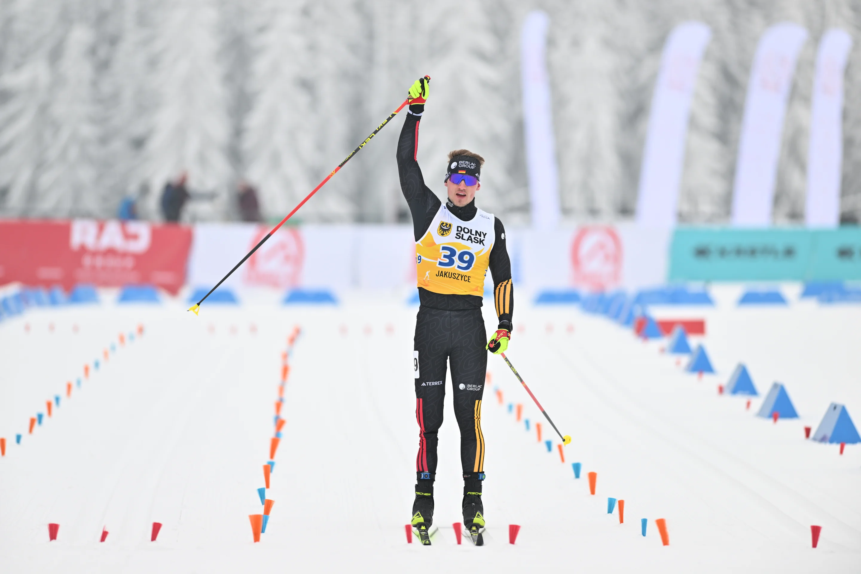Marburger raises his right arm in triumph as he crosses the line