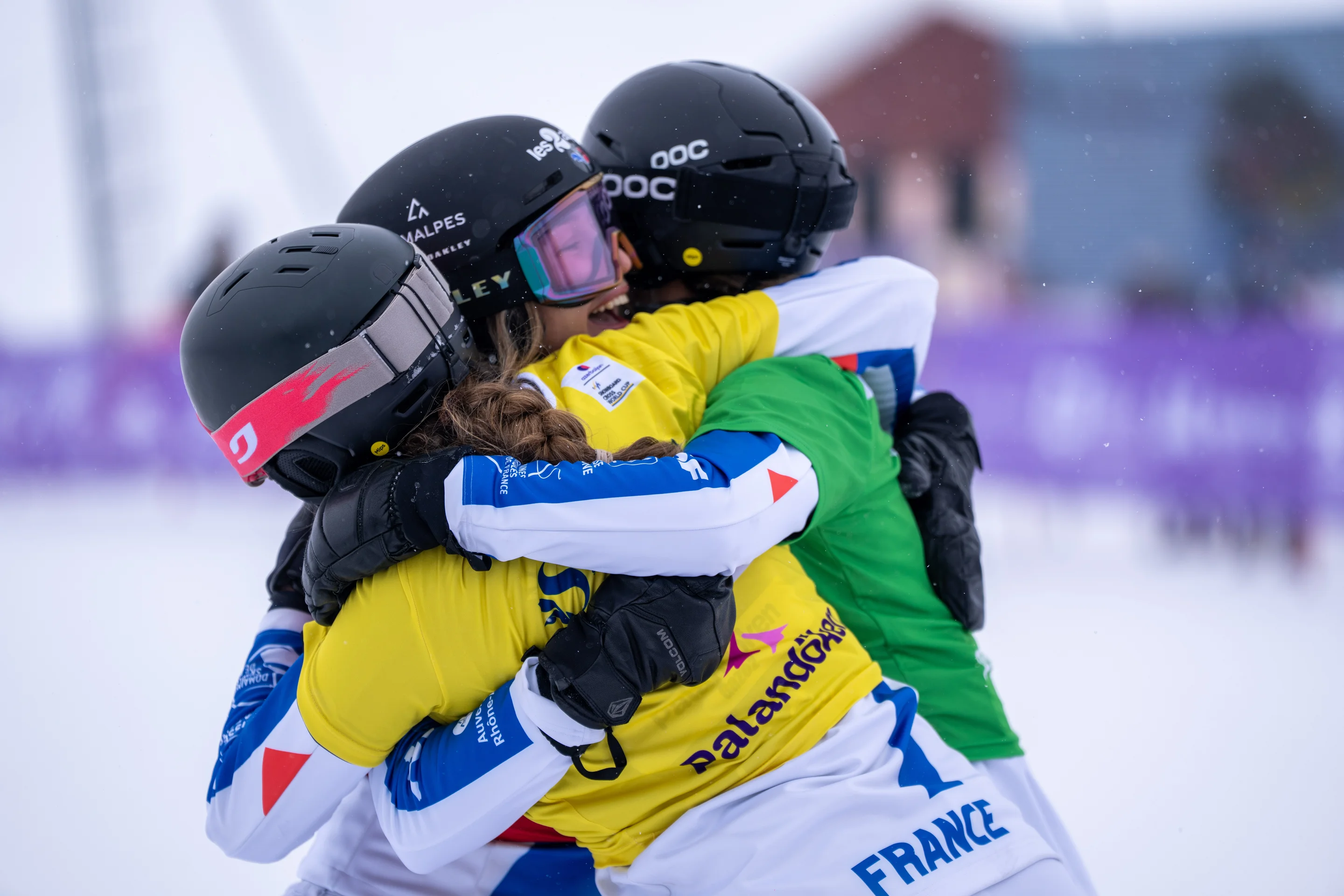 The three French snowboarders embrace after finishing, all smiles