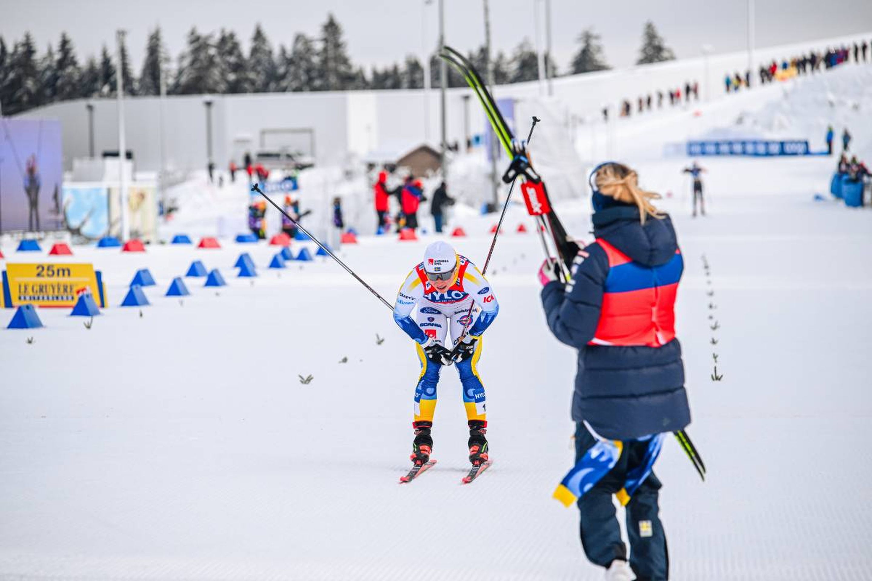 A relieved Jonna Sundling (SWE) crosses the finish line to bring the first place to Sweden, celebrated by her teammates © NordicFocus